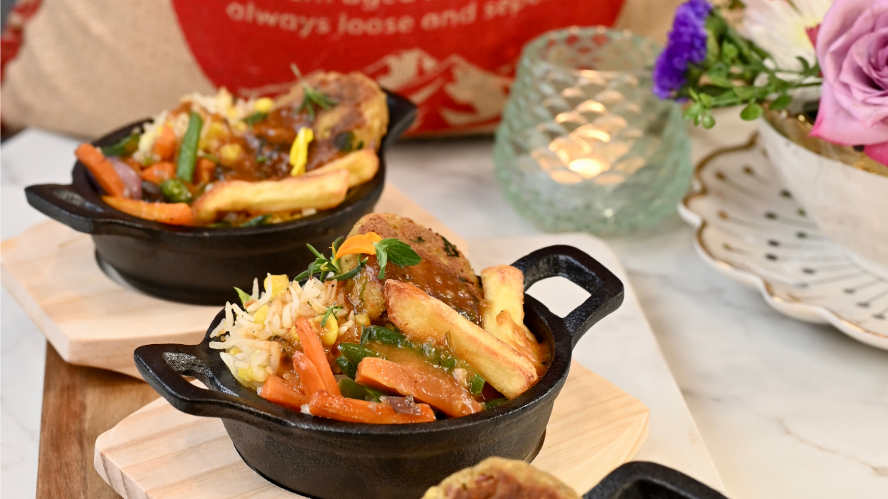 Hot Garlic Paneer Kebab Sizzler with Royal Basmati rice, garlic corn, sautéed veggies, and fries in cast-iron bowls